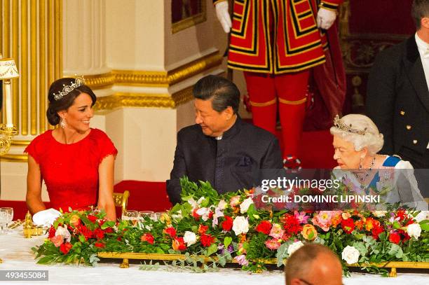 Chinese President Xi Jinping sits between Britain's Catherine, Duchess of Cambridge, and Britain's Queen Elizabeth II during State Banquet at...