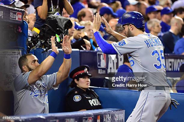 Eric Hosmer of the Kansas City Royals celebrates with Kendrys Morales of the Kansas City Royals in the dugout after scoring a run in the first inning...