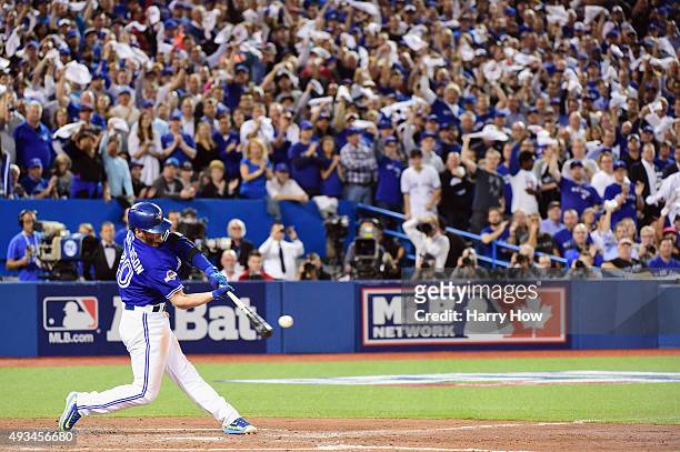 Josh Donaldson of the Toronto Blue Jays hits a ground rule double to score Ryan Goins of the Toronto Blue Jays in the third inning against the Kansas...