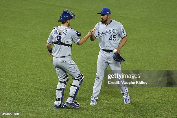 Drew Butera of the Kansas City Royals and Franklin Morales of the Kansas City Royals celebrate defeating the Toronto Blue Jays 14-2 in game four of...