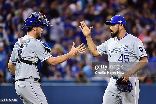 Drew Butera of the Kansas City Royals and Franklin Morales of the Kansas City Royals celebrate defeating the Toronto Blue Jays 14-2 in game four of...