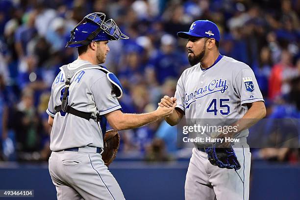 Drew Butera of the Kansas City Royals and Franklin Morales of the Kansas City Royals celebrate defeating the Toronto Blue Jays 14-2 in game four of...