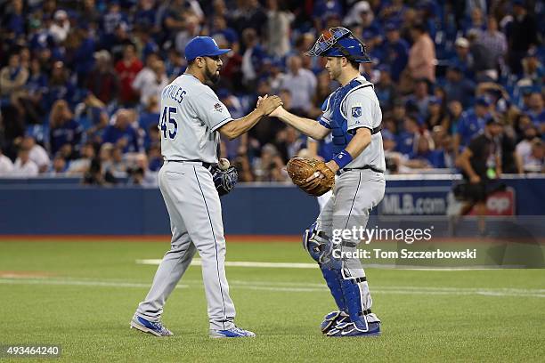 Franklin Morales of the Kansas City Royals and Drew Butera of the Kansas City Royals celebrate defeating the Toronto Blue Jays 14-2 in game four of...