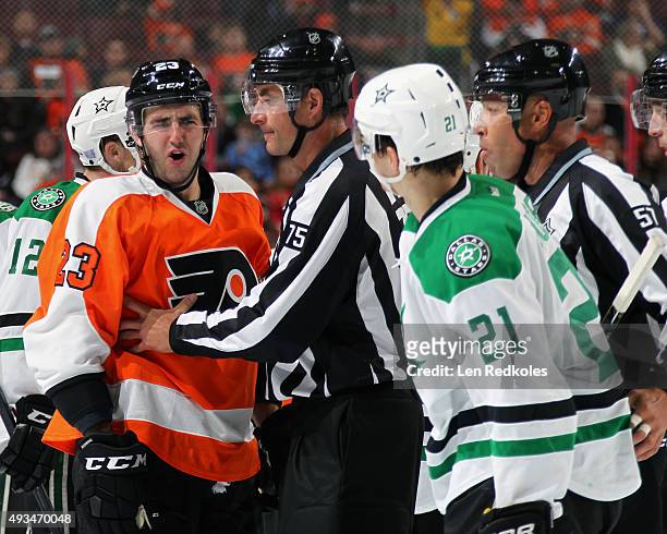 Linesmen Derek Amell and Jay Sharrers separate Brandon Manning of the Philadelphia Flyers from Antoine Roussel of the Dallas Stars during a second...