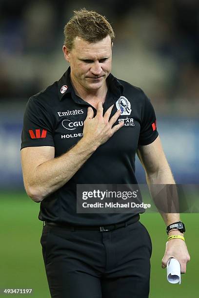 Magpies coach Nathan Buckley walks offloads the ball in a tackle at three quarter time during the round 10 AFL match between the Collingwood Magpies...