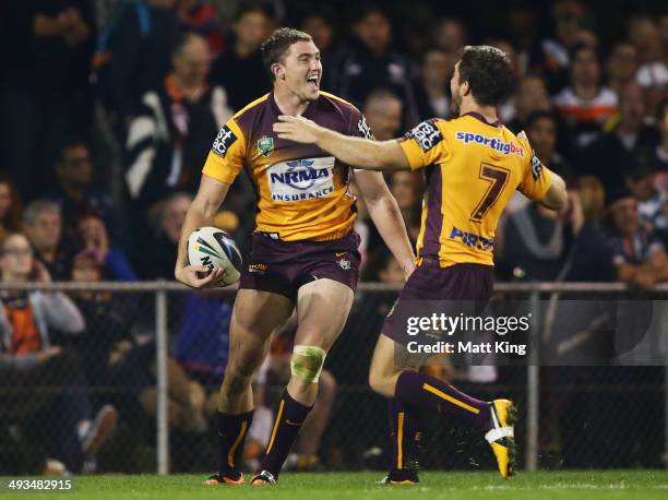 Corey Oates of the Broncos celebrates with Ben Hunt after scoring a try during the round 11 NRL match between the Wests Tigers and the Brisbane...