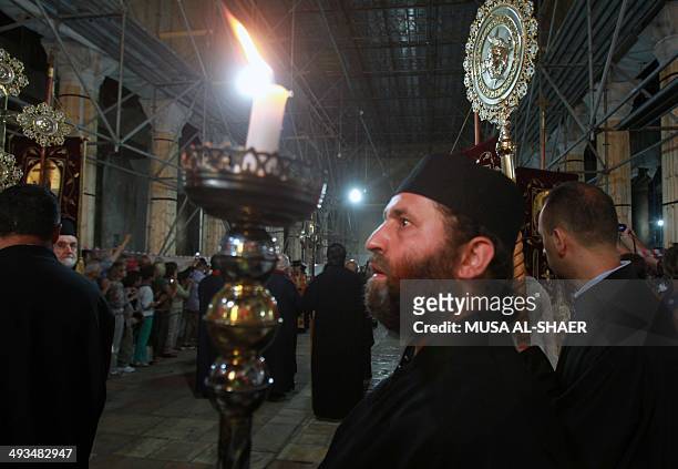 An Orthodox clergyman holds a candle before the arrival of Ecumenical Patriarch of Constantinople Bartholomew I at the Church of the Nativity,...