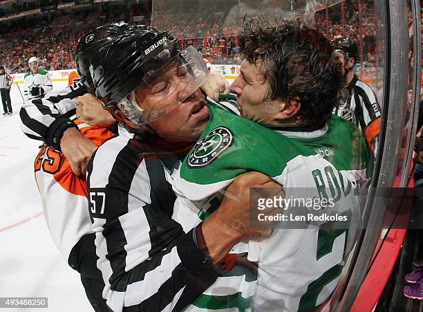 Linesman Jay Sharrers breaks up a scrum between Ryan White of the Philadelphia Flyers and Antoine Roussel of the Dallas Stars in NHL action on...