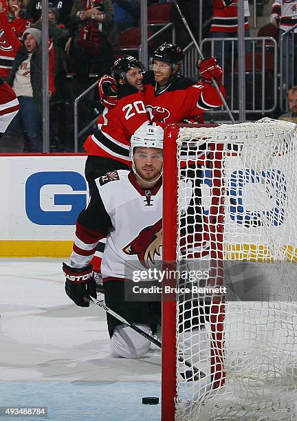 Adam Larsson of the New Jersey Devils celebrates his game winning goal at 43 seconds of overtime against the Arizona Coyotes and is joined by Lee...