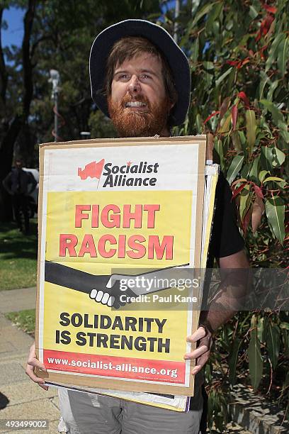 Protester holds a placard and chants as Dutch MP Geert Wilders holds a press conference outside the Western Australian Parliament House on October...