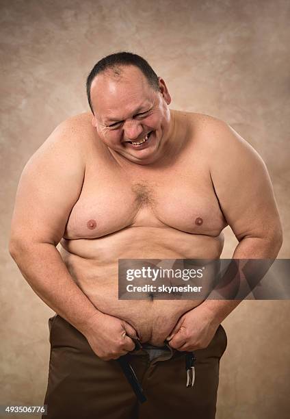 脂肪をしようとする彼のボタンなパンツです。 - belly button ストックフォトと画像
