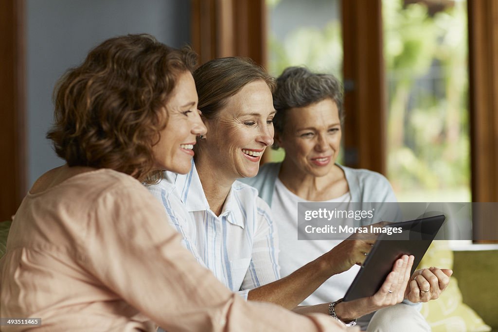 Happy women using digital tablet together