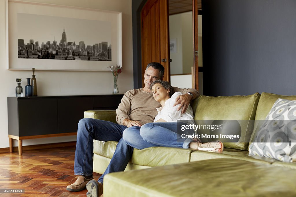 Thoughtful mature couple relaxing on sofa