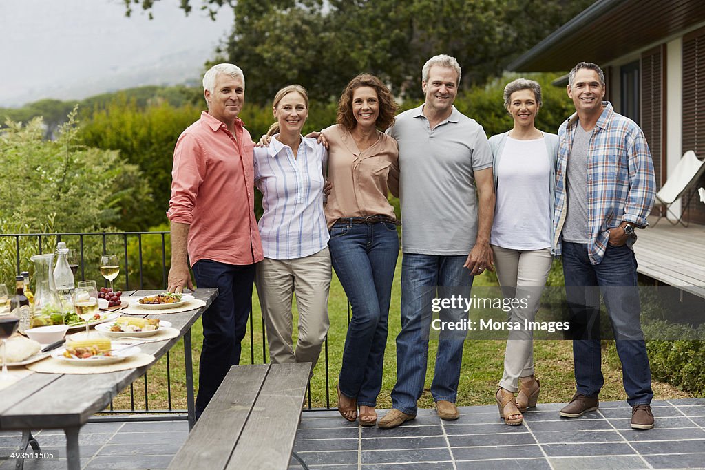 Mature friends standing at yard