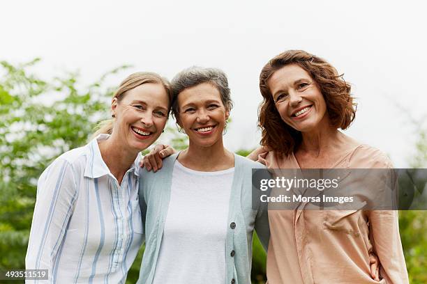 happy mature women standing in park - three people portrait stock pictures, royalty-free photos & images