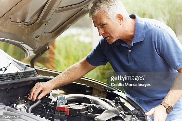 man fixing his car engine - capô de carro imagens e fotografias de stock
