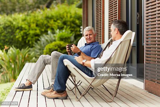 male friends spending leisure time at yard - veranda fotografías e imágenes de stock