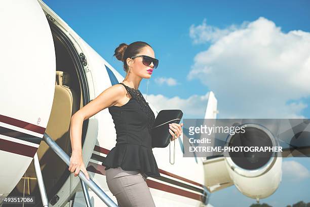 elegante mujer salir del avión reactor privado - model woman high end fotografías e imágenes de stock