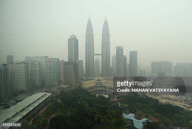 Malaysia's iconic Petronas twin towers and Kuala Lumpur's skyline are shrouded in thick haze on October 21, 2015. Fires raging across huge areas of...