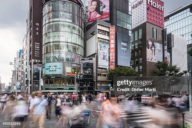 People cross the street with motion blur in the heart of Ginza, the place for luxury shopping in Tokyo, Japan.