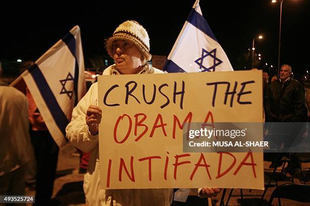 Jewish settlers, holding up anti-Obama placards and waving national Israeli flags, demonstrate against the United State's policy against the...