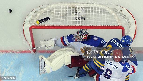 Russia's goalie Sergei Bobrovski saves his net, as Russia's defender Denis Denisov vies with Sweden's forward Jimmie Ericsson during a semifinal game...