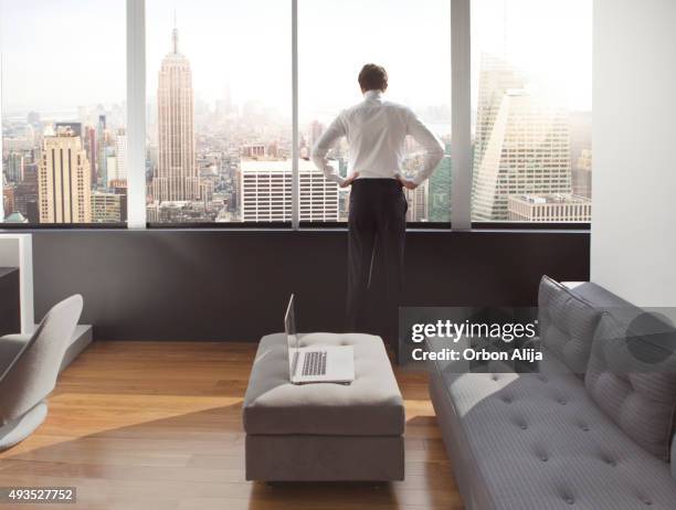 young man looking out at city skyline - corporate skyline stock pictures, royalty-free photos & images