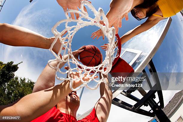 vielfältige gruppe, junge erwachsene basketball spielen.  low angle view.  ziel. - basketball net stock-fotos und bilder