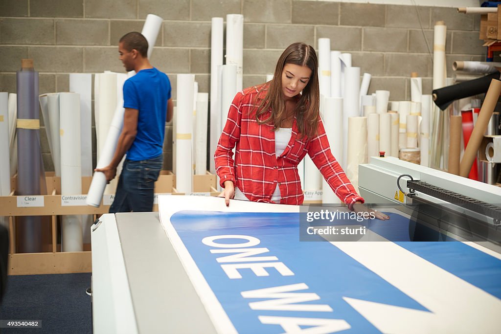Junge Frau, die Arbeit an einem digitalen Print-Firma