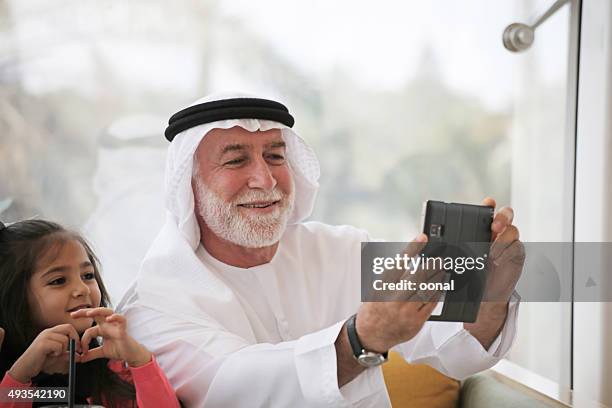 arab family being taken selfie photograph - emirati couple stock pictures, royalty-free photos & images