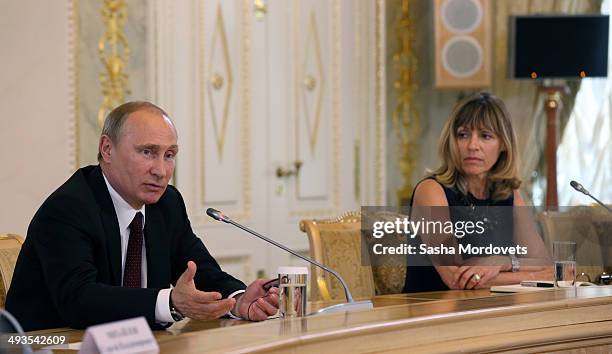 Russian President Vladimir Putin speaks at a panel with AFP's Regional Director for Europe Africa, Florence Biedermann during a meeting with...