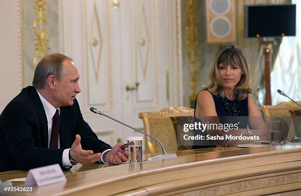 Russian President Vladimir Putin speaks at a panel with AFP's Regional Director for Europe Africa, Florence Biedermann during a meeting with...