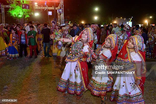 Indian 'garba' performers carry 'selfie sticks' during a dance performance on the 'eighth night of nine nights' termed 'Navratri' at the Rajpath Club...