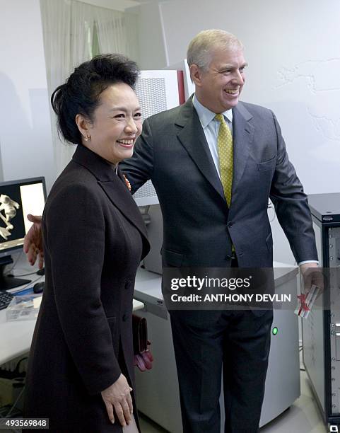 Chinese First Lady Peng Liyuan and Britain's Prince Andrew, Duke of York, reacts as they are shown medical equitpment during a Hamlyn Centre for...