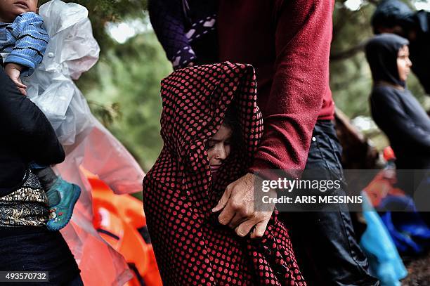 Man covers a child with a blanket after arriving with other refugees and migrants on the Greek island of Lesbos after crossing the Aegean sea from...