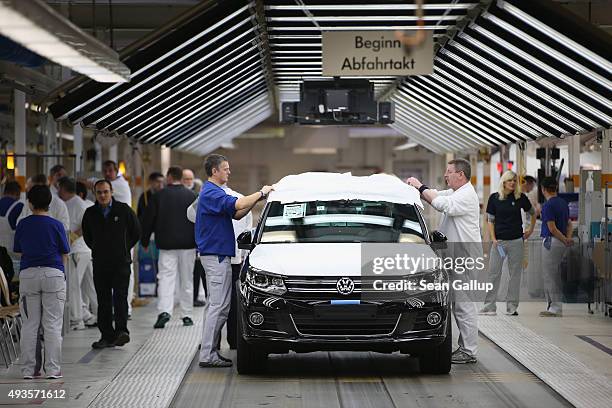 Workers conduct final inspections and prepare finished Volkswagen cars for transport at the end of the assembly line prior to a visit by Volkswagen...