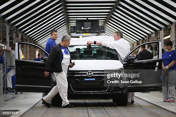 Workers conduct final inspections and prepare finished Volkswagen cars for transport at the end of the assembly line prior to a visit by Volkswagen...