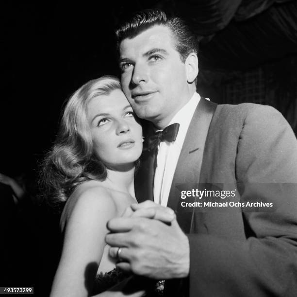 French actress Corinne Calvet dances with husband actor John Bromfield at a dinner in Los Angeles, California.