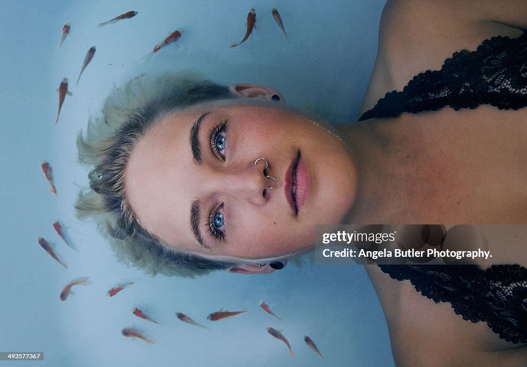 Girl in the water with goldfish