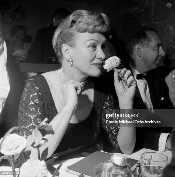 Actress Eve Arden smells a flower at Screen Directors Award dinner in Los Angeles, California.