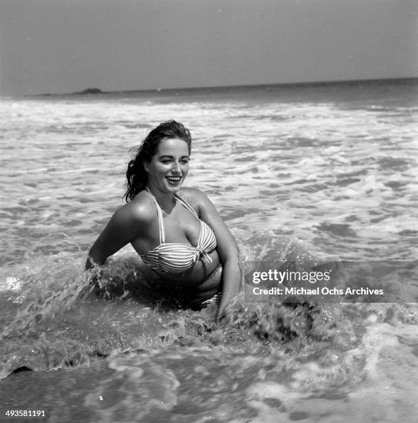 Jackie Collins poses in the ocean in Los Angeles, California.