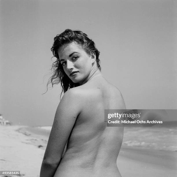 Jackie Collins poses on the beach in Los Angeles, California.