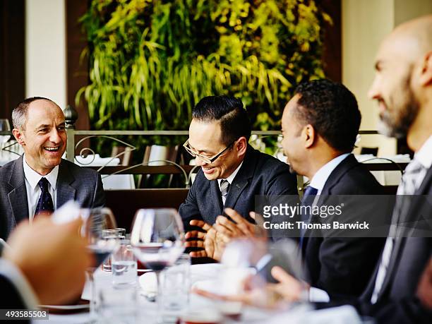 group of laughing businessmen at lunch meeting - business lunch stock-fotos und bilder