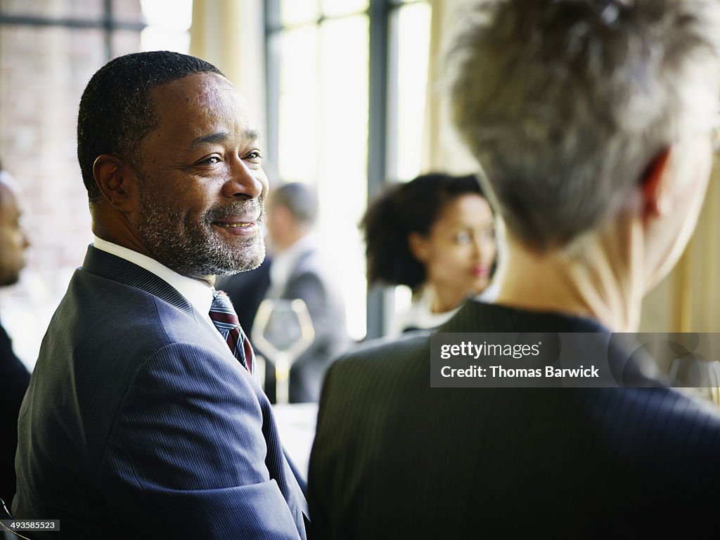 Smiling businessman at table during lunch meeting