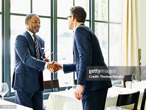 two businessmen shaking hands at lunch meeting - meal deal stock pictures, royalty-free photos & images