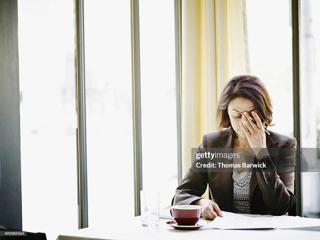 Businesswoman at table with head resting on hand