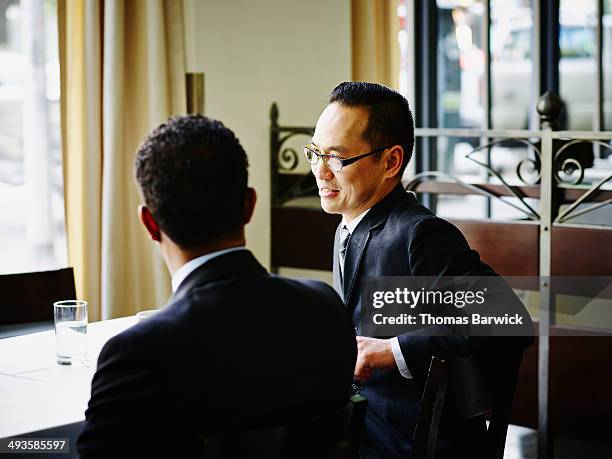 businessmen in discussion at table in restaurant - conference dining table stockfoto's en -beelden