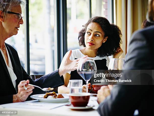 businesswoman in restaurant listening in meeting - business lunch stock pictures, royalty-free photos & images