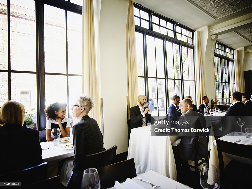 Businessman and businesswoman flirt across tables