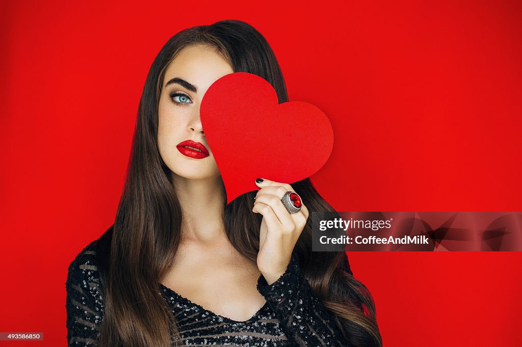 Beautiful woman holding artificial heart